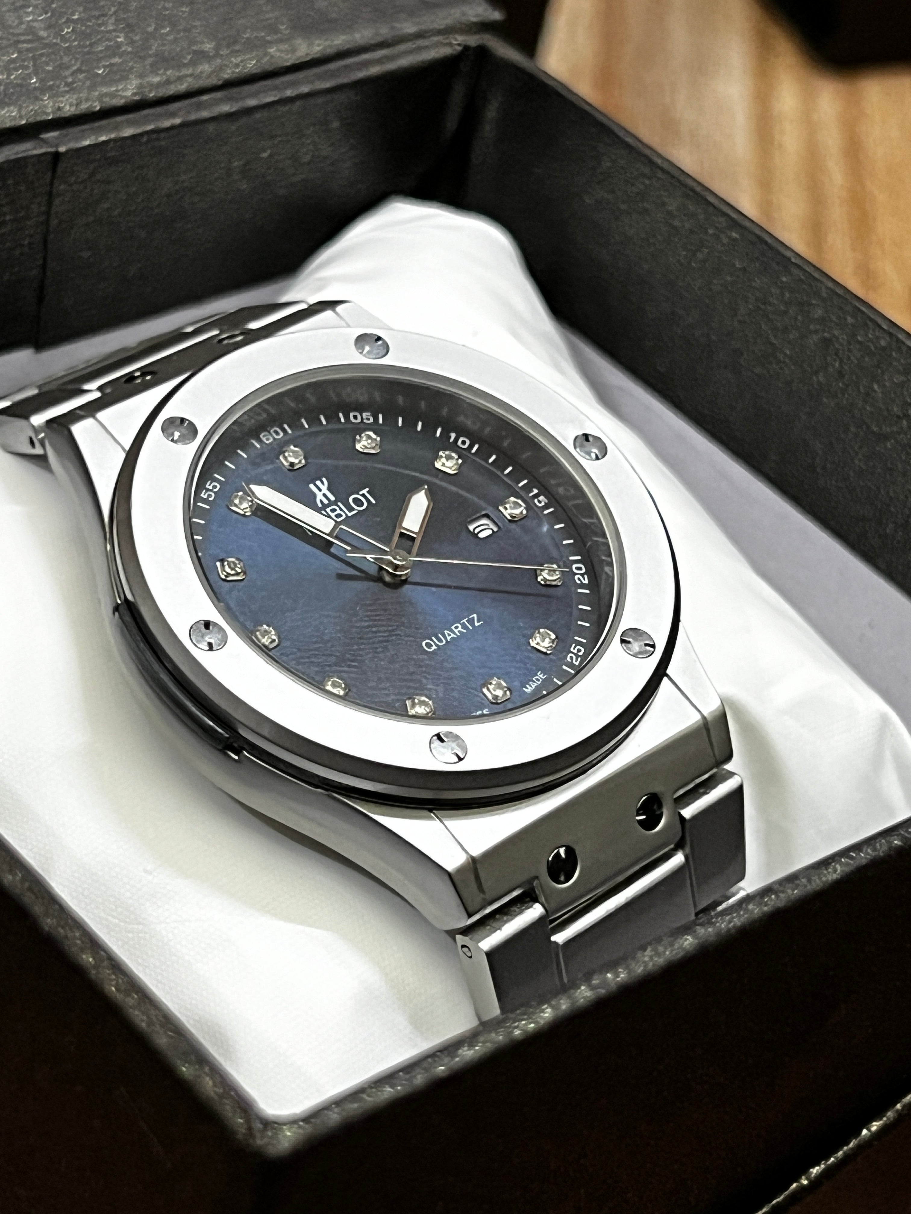 Luxury watch with blue face and silver case in a box