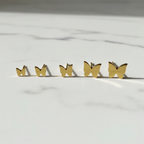 Gold Butterfly Stud Earrings Set on White Marble Surface