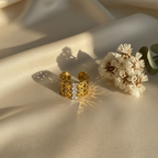 Gold lace ring on silk flat lay with flowers